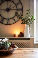 Vintage jug with stems of holly in modern country kitchen 