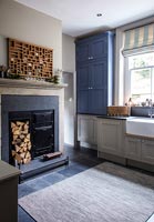 Wood burner and log store in modern country kitchen