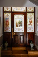 Ornate stained glass in classic wooden door and surrounding windows