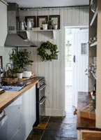 Wood paneled galley kitchen with Christmas wreath on wall