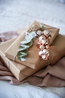 Gifts wrapped in brown paper with decorative jingle bells 