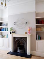 Fireplace with modern neon art and built in shelving units 