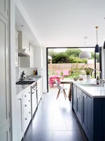 Modern kitchen with open doors to garden 