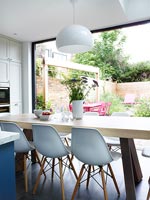 Large dining table in modern kitchen overlooking garden 