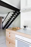 Wooden kitchen cabinet and black and white staircase 