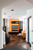 Orange Television unit and log burning stove in modern living room  