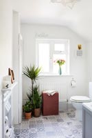 Modern bathroom with patterned floor tiles and houseplants 