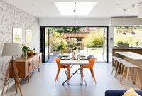 Modern kitchen diner with bi-fold doors to garden wide open 