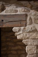 Exposed stone wall and beams over door