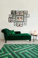 Green chaise lounge and display of photographs 