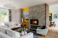 Lit fire in contemporary living room with view through to dining table 