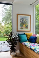 Colourful window seat and framed painting 