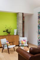 Lime green feature wall in contemporary dining room with vintage furniture 