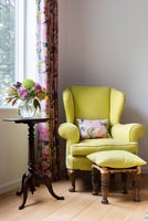 Classic yellow armchair by window 
