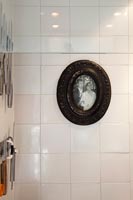Black and white photograph in oval frame on tiled wall 