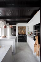 Contemporary monochrome kitchen with splashback tiles above range cooker 