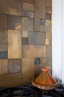 Copper splashback tiles above cooker 