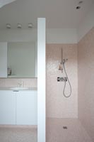 Shower in modern bathroom with pink tiling 