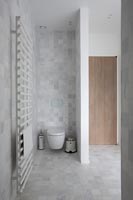 Contemporary bathroom with toilet and partition wall for privacy 