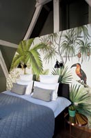 Painted tropical scene as back drop to bed in modern bedroom 