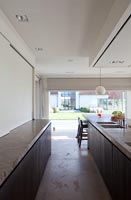 Contemporary kitchen with view to garden through open patio doors 