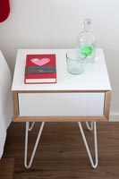 Small bedside cabinet with drink of water and romantic book 