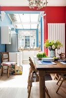 Red and blue painted walls in modern kitchen-diner 