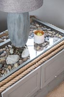 Glass top table revealing display of pebbles inside 
