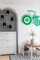 Chest of drawers in alcove and tractor mural in childrens room 