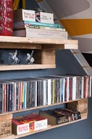 Books and CDs on wooden shelves made from pallets