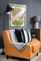 Orange leather chair in living room with dark grey walls 