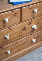 Decorative knobs on wooden chest of drawers  