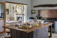 Modern country kitchen with copper splash backs above range cooker 