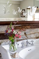 Decorative carved mirror above sink in country bathroom 