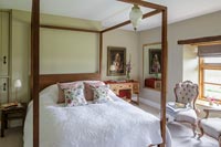 Wooden four poster bed in country bedroom 
