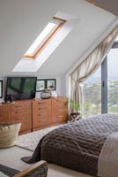 Modern bedroom with large chest of drawers and coastal views 
