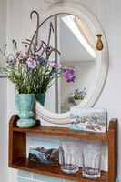 Flower arrangement on shelf by mirror 