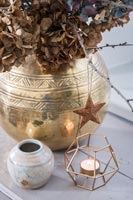 Copper star on gold pot of dried flowers 