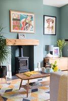 Wood burning stove in modern living room with teal painted walls 