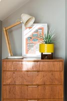 Chest of drawers with plant, lamp and framed picture 