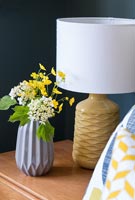 Small vase of flowers and table lamp 