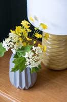 Small vase of flowers and table lamp 