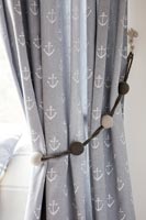 Curtains with anchor motif tied back with decorative rope