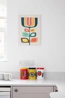 Colourful storage jars and artwork in modern kitchen 