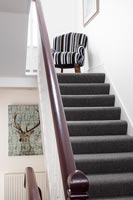 Stripy armchair on landing at top of staircase 
