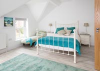 Modern bedroom with aqua blue soft furnishings 