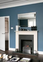 White fireplace and dark blue painted walls 
