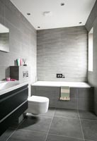 Modern bathroom with grey tiling on floor and walls 