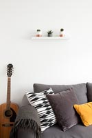 Tiny shelf above sofa in modern living room 