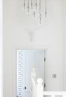 Clear glass light in white hallway 